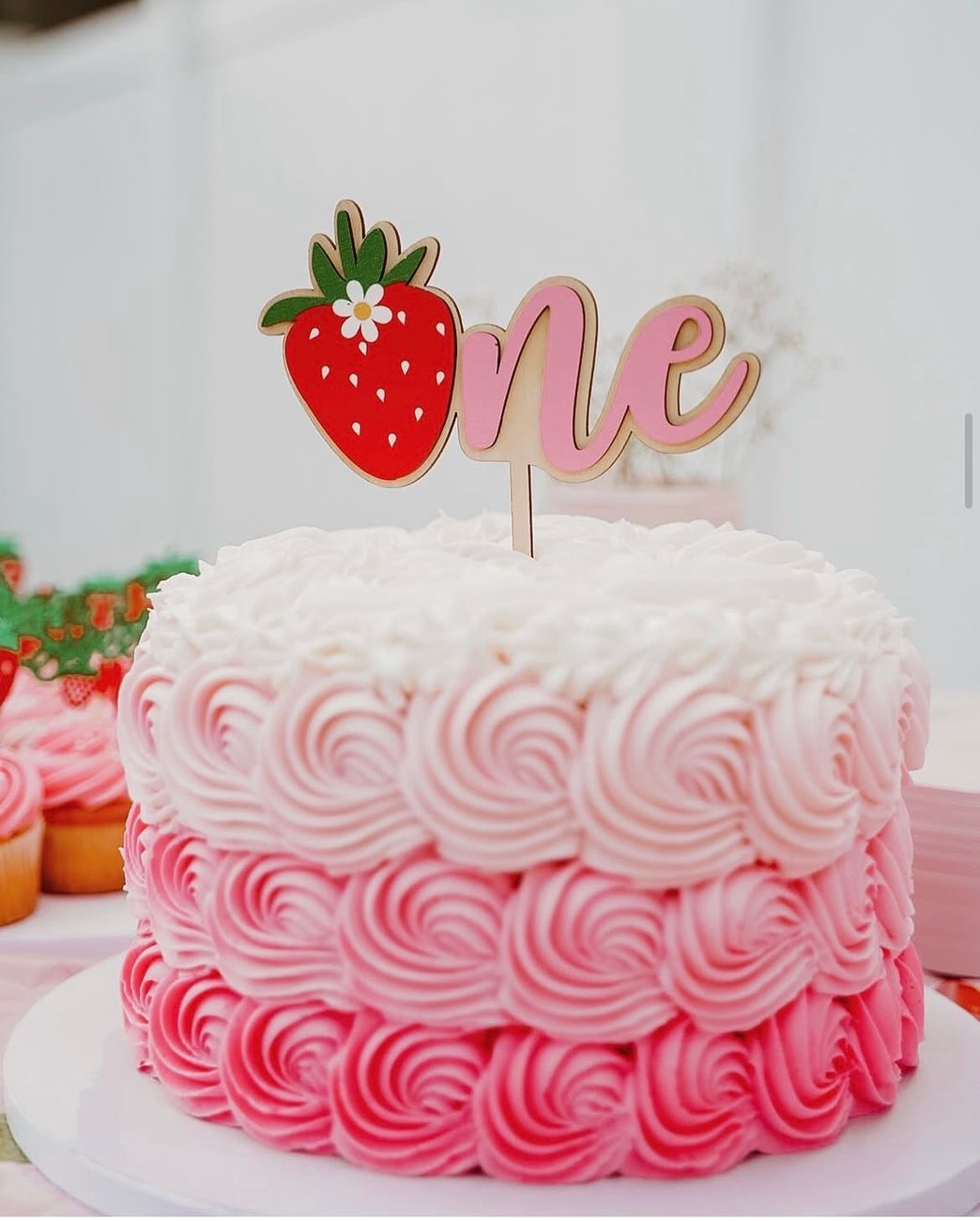 Pink ombré rosette smash cake with a strawberry one topper