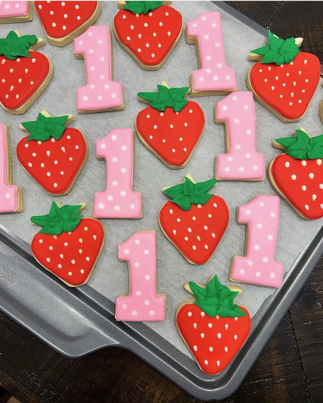 Strawberry and pink number-one cookies for a first birthday