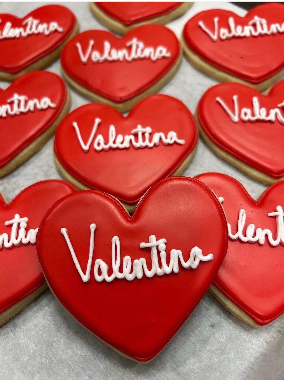 Red heart cookies hand-lettered with the name Valentina